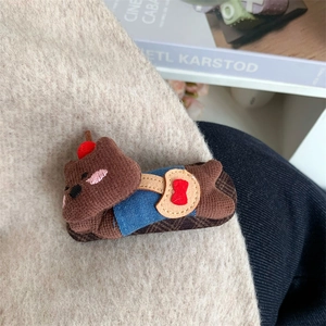Primer plano de horquilla para perro de peluche con bordado y lazo rojo sobre tela de tweed