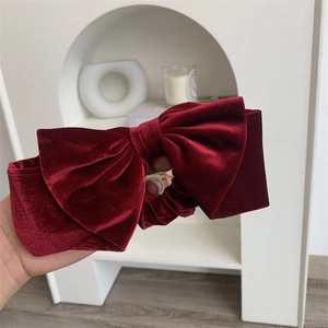 Gros plan d'un chouchou noeud en velours rouge foncé avec texture soyeuse