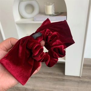 Gros plan sur l'élastique en velours rouge foncé avec une étiquette textile Hand Made