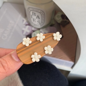 Sweet acetic acid hair clip with 3D white flowers and pearls on amber texture