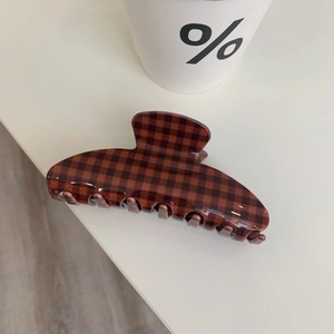 Detail view of large tortoiseshell checkered hair claw clip with glossy finish