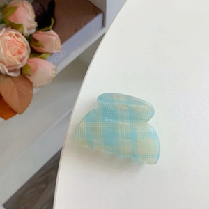 Süße hellblaue Haarklammer mit gelbem Karomuster auf weißem Hintergrund präsentiert