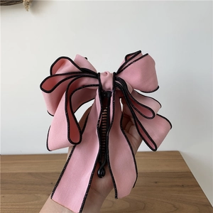Detail showing the pink fabric ribbon layers and black banana clip closure mechanism