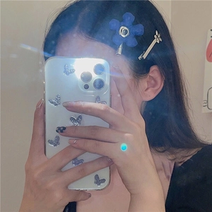 Detailopname van een blauwe stoffen bloem haarclip en zilveren speld bij een model