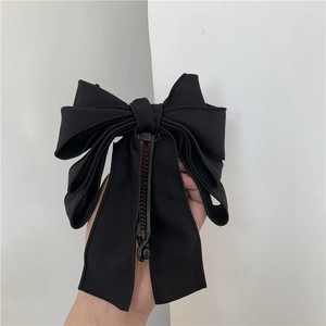 Detail of multi-layered black fabric bow banana hair clip for ponytail styling