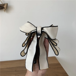 Elegant multi-layered cream fabric bow hair clip with black piping and banana clip