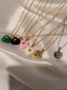 Détails de colliers avec pendentifs en cœur multicolores sur fond de satin blanc