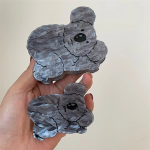 Detailed view of two gray marble acetate hair claws in cute koala and bear shapes