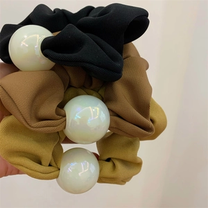 Makro-Detail von dreifarbigem Scrunchie-Set mit großen schillernden Perlen und Rippstoff