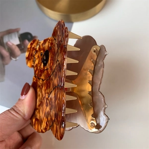 Detailed view of an amber acetate koala hair claw clip with strong golden metal teeth