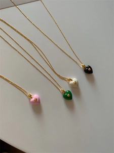 Vue détaillée de quatre colliers cœur en émail coloré avec chaînes dorées fines