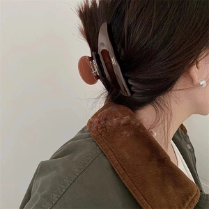 Close-up of a large tortoiseshell acetate hair claw clip styled in a classic French updo