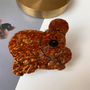 Detail view of acetate bear-shaped hair claw clip with amber marble pattern