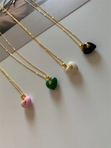 Vue détaillée des colliers pendentifs cœur en émail rose, vert, blanc et noir