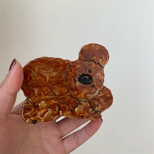 Close-up of a bear-shaped amber acetate claw clip with detailed black outlines