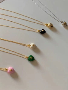 Détails de diverses couleurs de pendentifs cœurs en émail sur des chaînes délicates