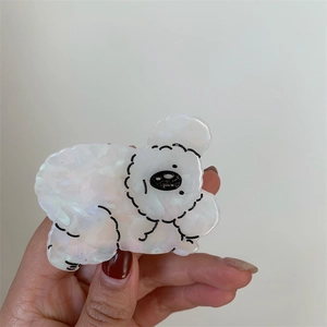 Detail of cute Bichon dog hair claw clip made from iridescent white acetate material