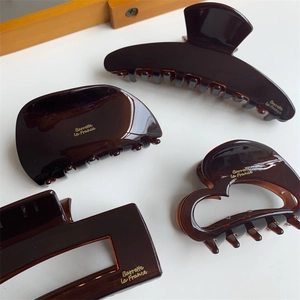Detailed macro of tortoise shell brown acetate hair clips with gold label inscriptions