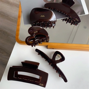Detailed view of assorted dark amber acetate hair claws with premium glossy resin finish