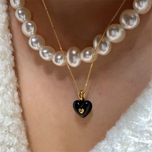 Collier minimaliste à pendentif coeur noir superposé de perles sur chaîne dorée