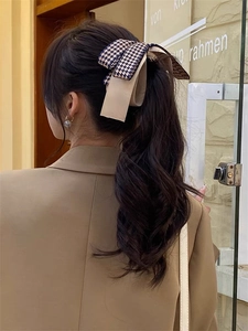 Barrette à cheveux élégante avec nœud pied-de-poule sur cheveux foncés, vue de derrière