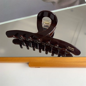 Detail of dark amber hair claw clip with golden Barrette La France text engraving