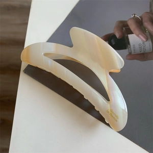 Détail d'une pince à cheveux en acétate perlé avec inscription dorée Barrette La France