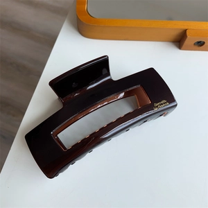 Macro detail of tortoiseshell acetate hair claw with gold Barrette La France text logo