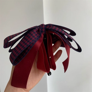 Détail du nœud élégant en velours rouge et pied-de-poule bleu pour les cheveux
