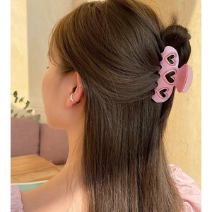 Pince à cheveux rose avec cœurs découpés, aspect mat, portée par un mannequin