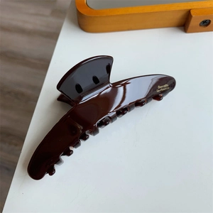 Detail shot of the golden Barrette La France lettering on a brown tortoiseshell hair claw