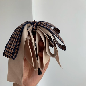 Détails du ruban pied-de-poule bleu et satin beige sur une pince à cheveux banane
