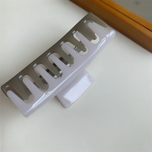 Detail of a large square hair claw clip in grey and white color block resin material