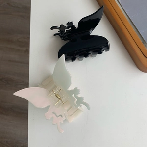 Détails de pinces à cheveux papillon évidées en noir brillant et blanc nacré élégant