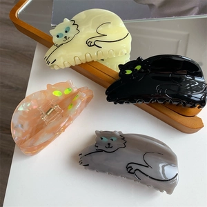 Detail view showing colorful cat-shaped acetate hair claws in four different glossy finishes