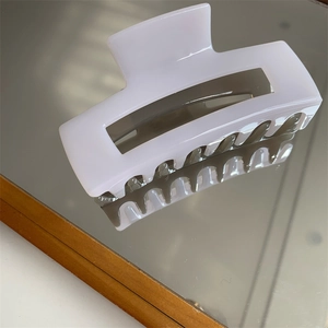 Detail of lavender matte rectangular hair claw clip with smooth resin finish on a mirror