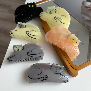 Detail showing various cat-shaped acetate hair claws in marble and solid colors