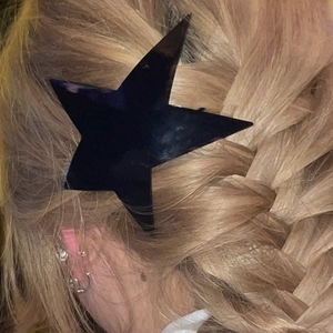 Close-up of trendy black star-shaped acrylic hair clip styled on braided hair