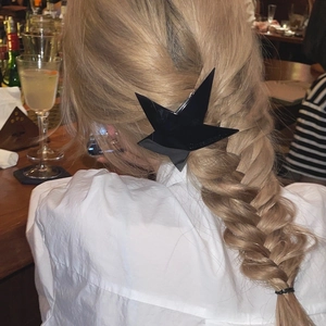 Minimalist black star hair clips set in acrylic material worn on a model hairstyle