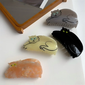 Detailed macro view of acetate hair claws in four colors with minimalist cat designs