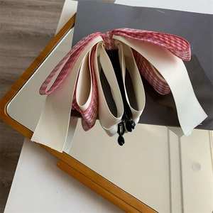 Détail des couches de ruban satiné et pied-de-poule sur cette pince banane de style français