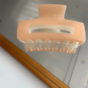 Detailed view of the square hollow hair claw clip in a soft matte pink finish