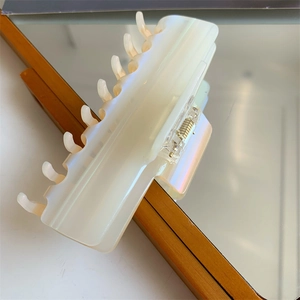 Détail de la grande pince à cheveux en acétate avec fini perlé iridescent sur bois