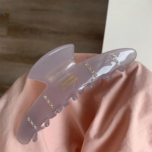 Détail de la pince à cheveux en acétate lavande avec strass et texte doré Barrette