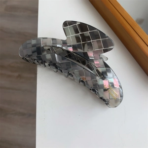 Détail de la pince à cheveux mosaïque grise avec fini nacré et lettrage doré
