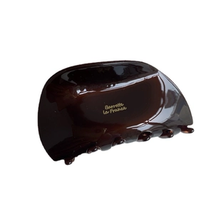 Dark brown tortoiseshell hair claw with gold Barrette La France lettering on white background