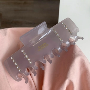 Détail de la pince à cheveux en acétate gris avec strass et texte doré Barrette La France