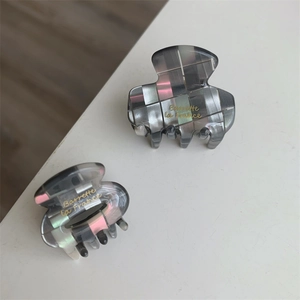 Détail de deux pinces à cheveux mosaïque grise avec gravure dorée Barrette la france