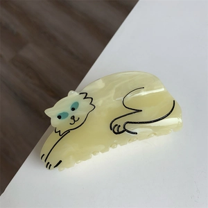 Detail of cream acetate hair claw clip featuring a cute cartoon sleeping cat design