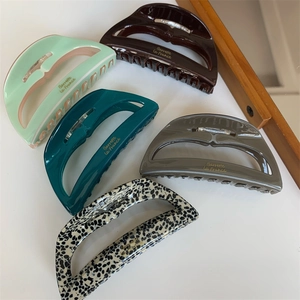 Detailed set of five acetate hair claw clips in various elegant colors and patterns